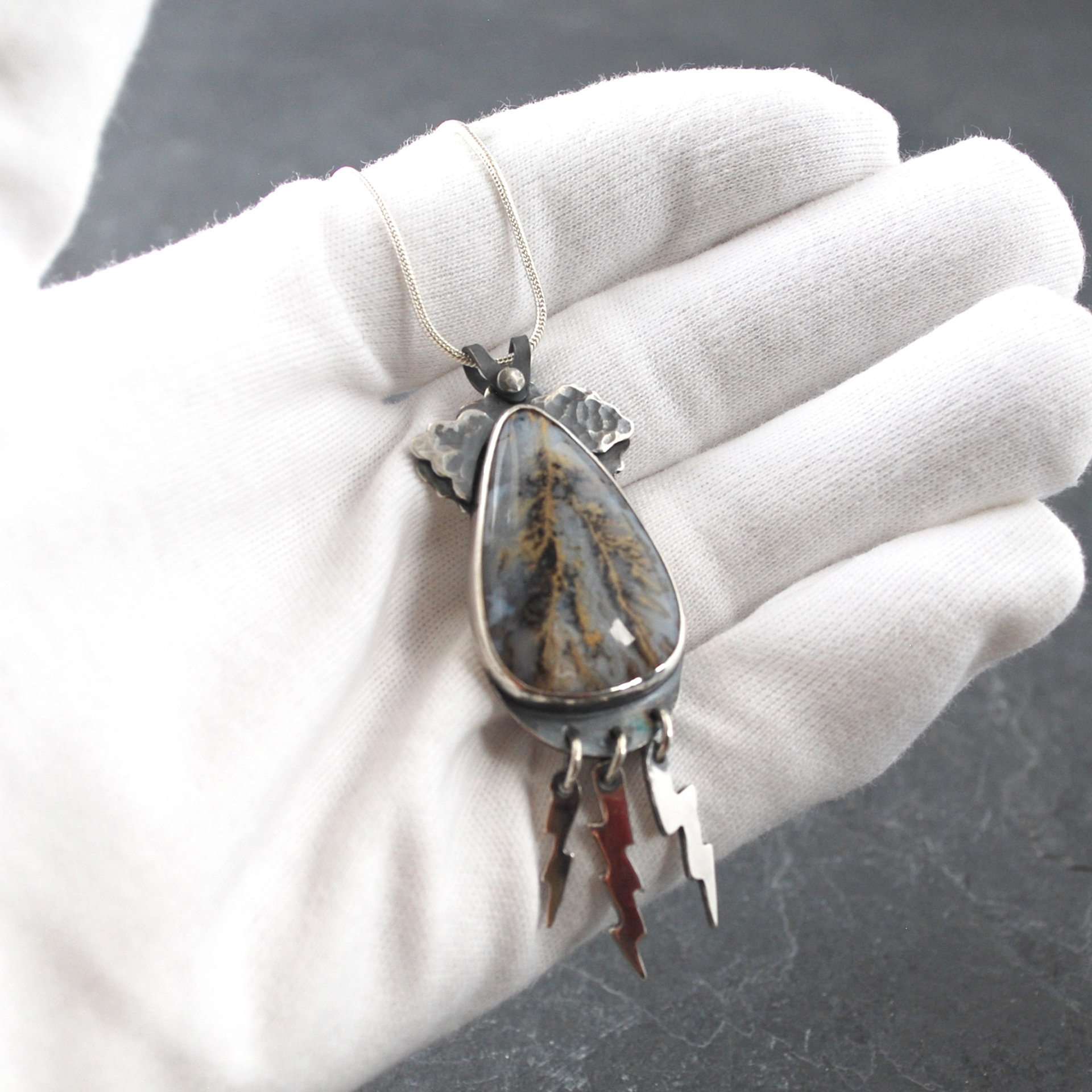 Graveyard Point Plume Agate Pendant with Lightning Bolts, in hand