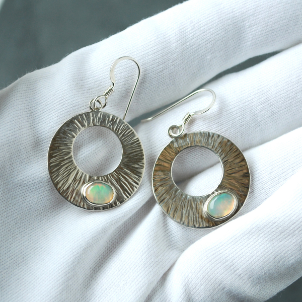 Silver Circle Earrings with Welo Opals in hand
