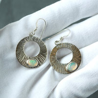 Silver Circle Earrings with Welo Opals in hand