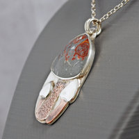 Silver pendant with rhyolite "mushroom cap, copper mushroom stem, two additional silver and copper mushrooms, close up angle