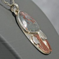 Silver pendant with rhyolite "mushroom cap, copper mushroom stem, two additional silver and copper mushrooms, close up angle