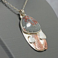 Silver pendant with rhyolite "mushroom cap, copper mushroom stem, two additional silver and copper mushrooms, close up angle