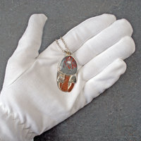 Silver pendant with rhyolite "mushroom cap, copper mushroom stem, two additional silver and copper mushrooms,  in hand