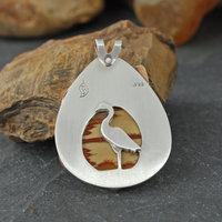 Owyhee Jasper and silver pendant back with heron in front of the cut-out stone back
