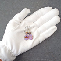 Pale purple Czech glass earrings, swallow embossed flat beads at bottom, topped by faceted rondelle beads, in hand