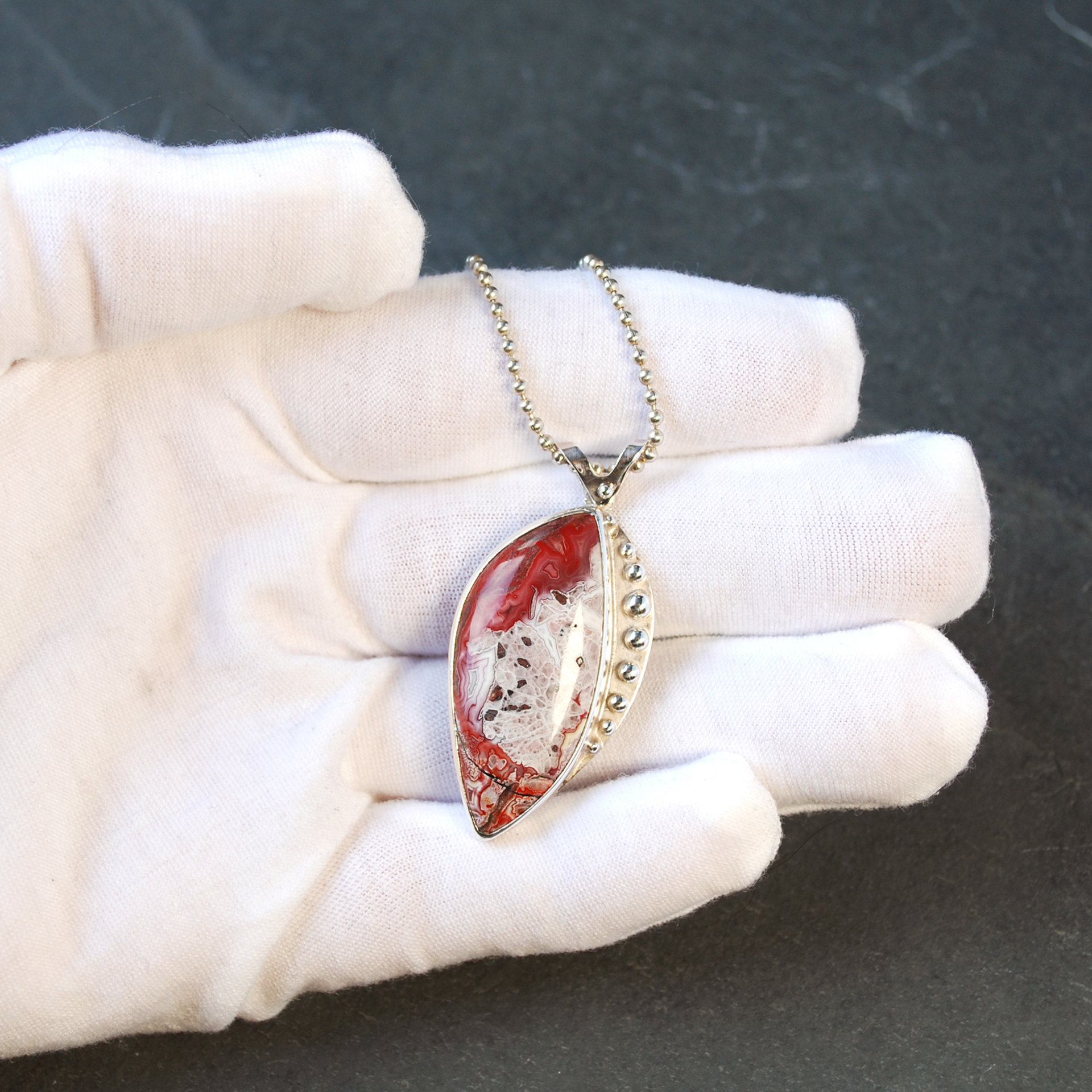 Crazy Lace agate pendant in hand