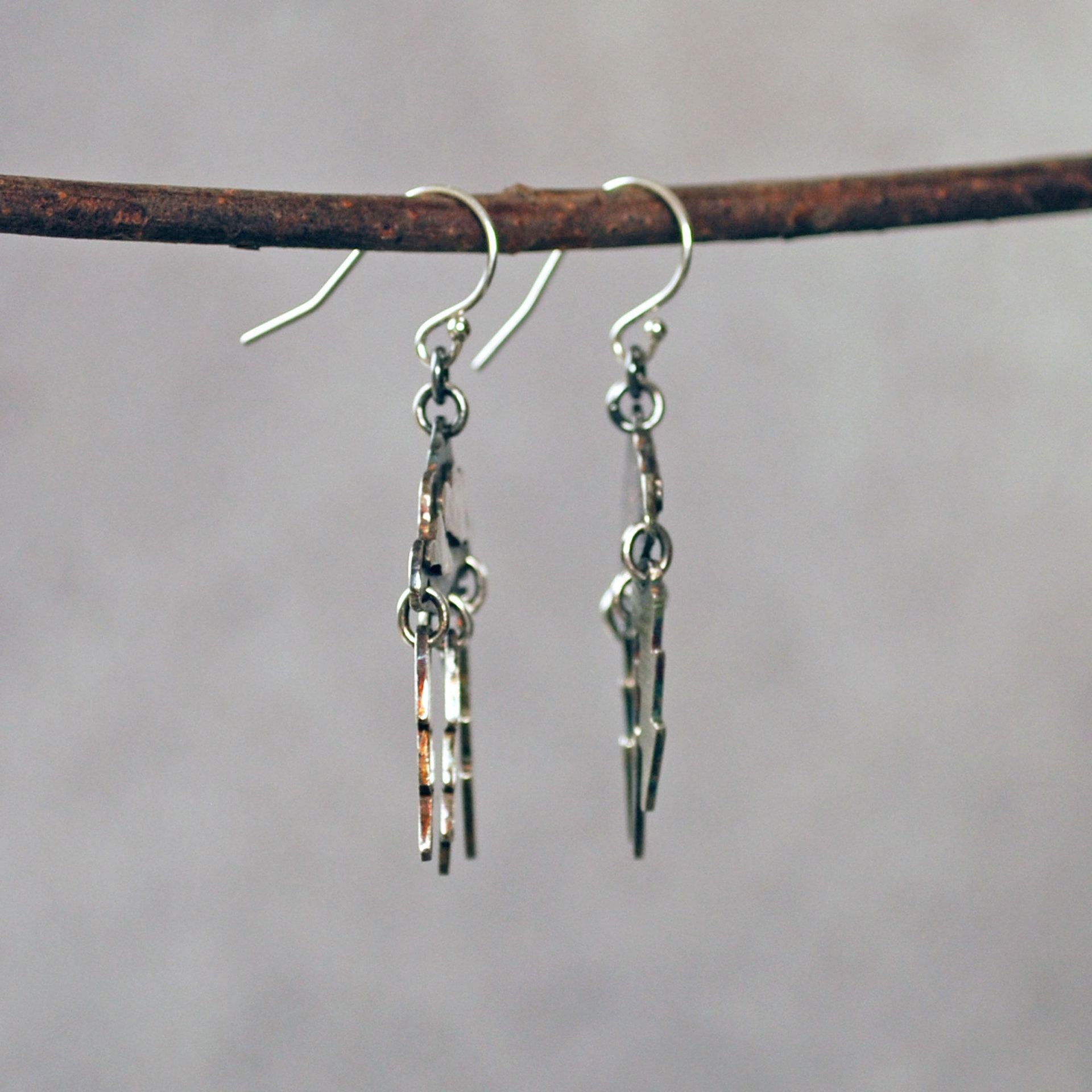 Silver Cloud Earrings with Lightning Bolts, hanging side view