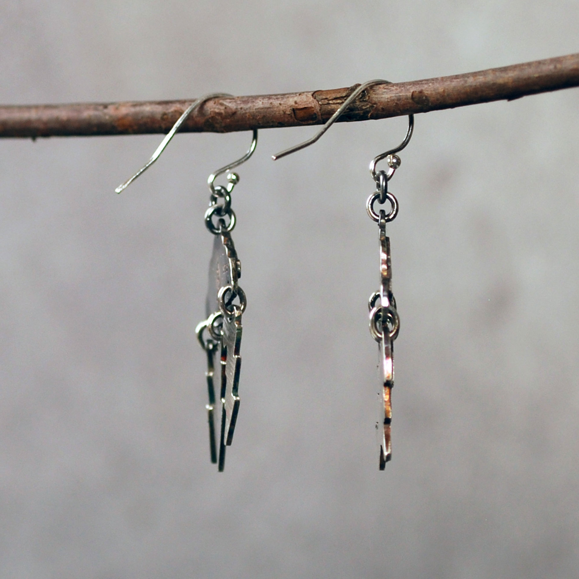 Silver Cloud Earrings with Lightning Bolts, hanging side view