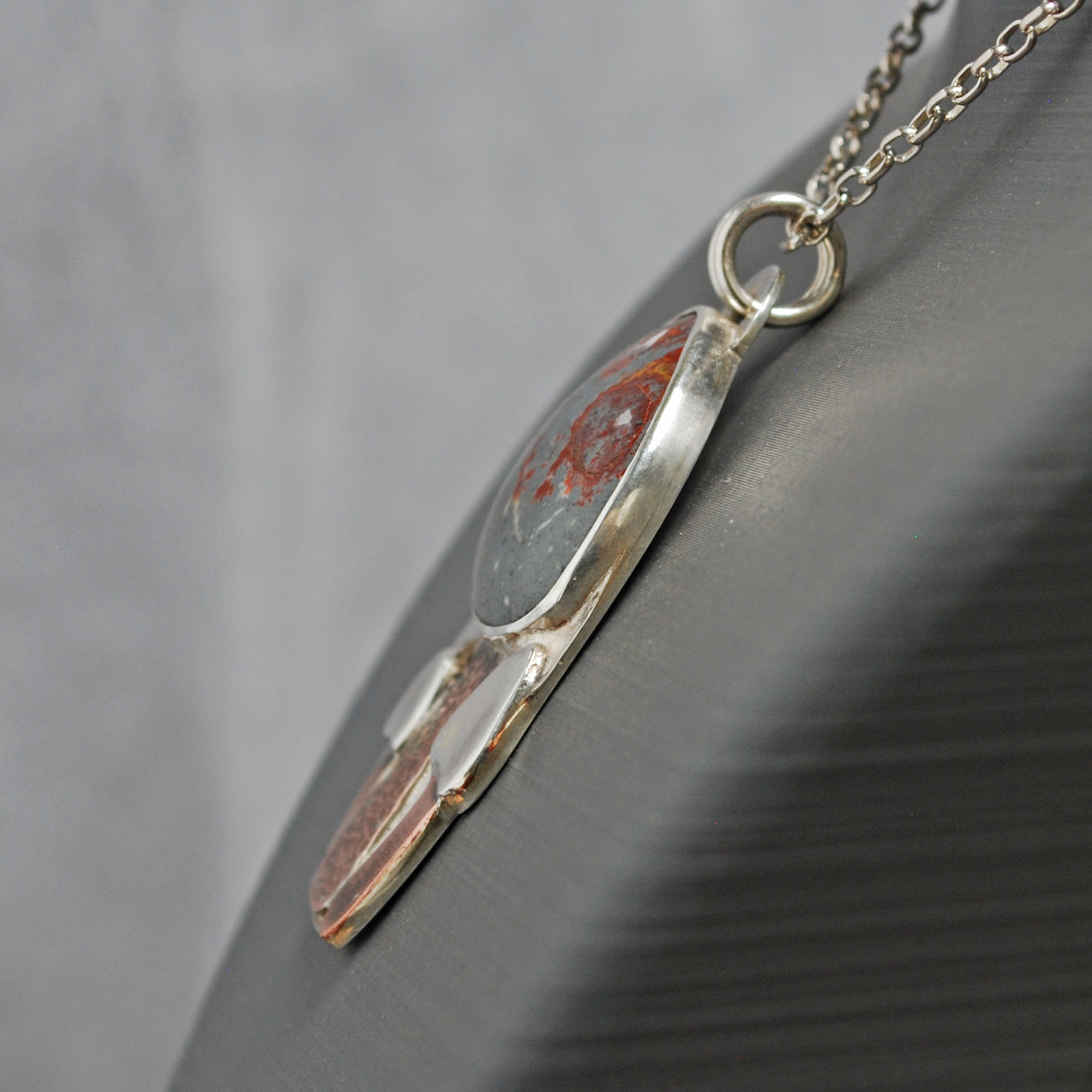 Silver pendant with rhyolite "mushroom cap, copper mushroom stem, two additional silver and copper mushrooms, close up angle