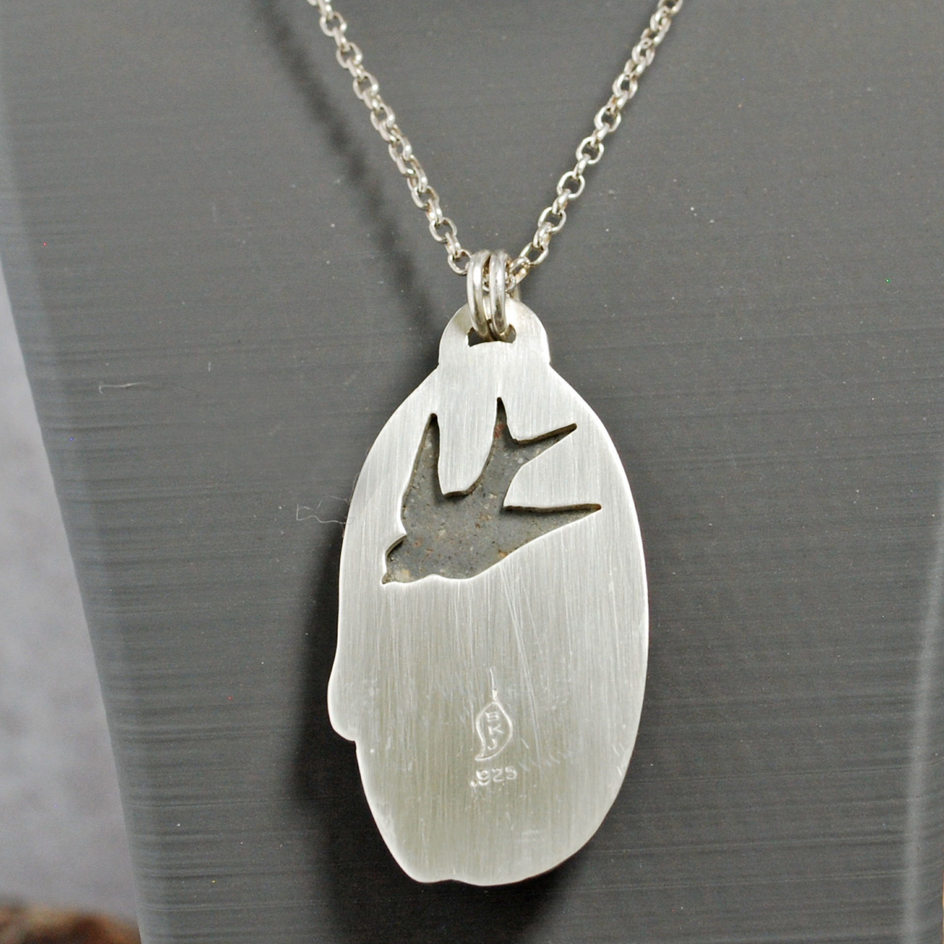 Silver pendant with rhyolite "mushroom cap, copper mushroom stem, two additional silver and copper mushrooms, close up back