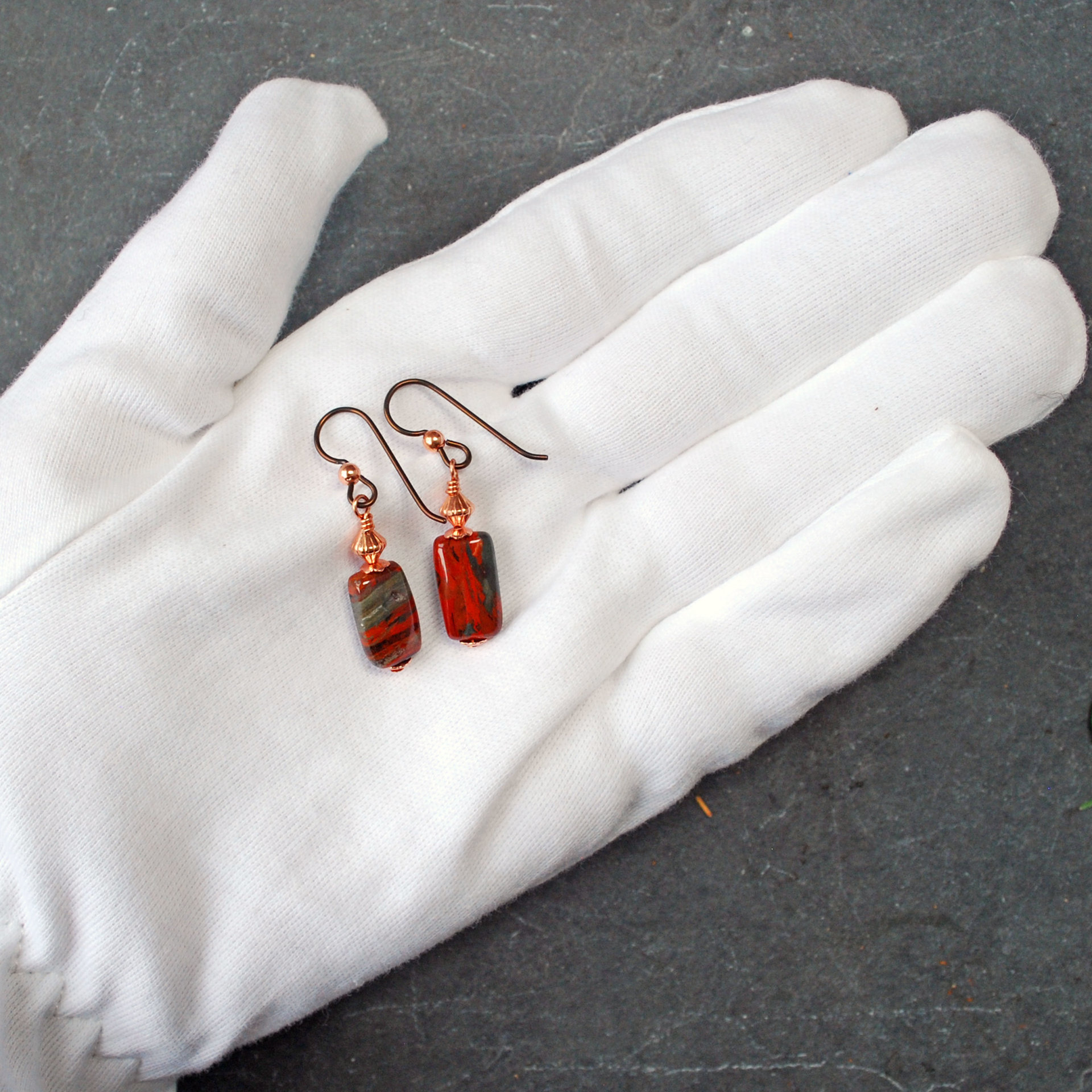 Dangling earrings with flame jasper and copper beads in hand