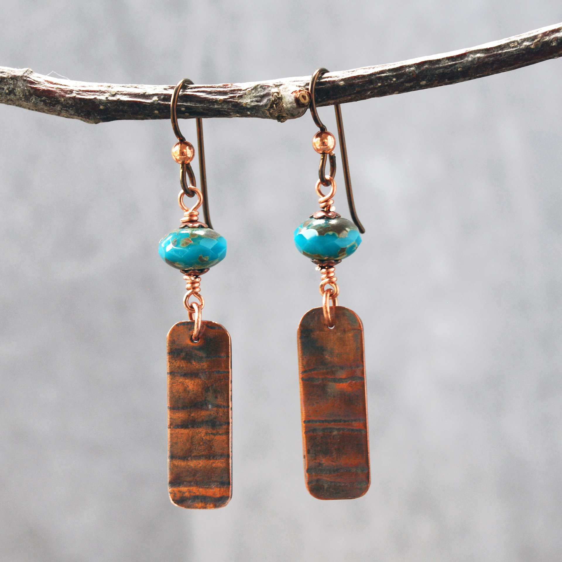 Earrings with corrugated copper rectangle dangles and turquoise Czech glass bead on top, hanging