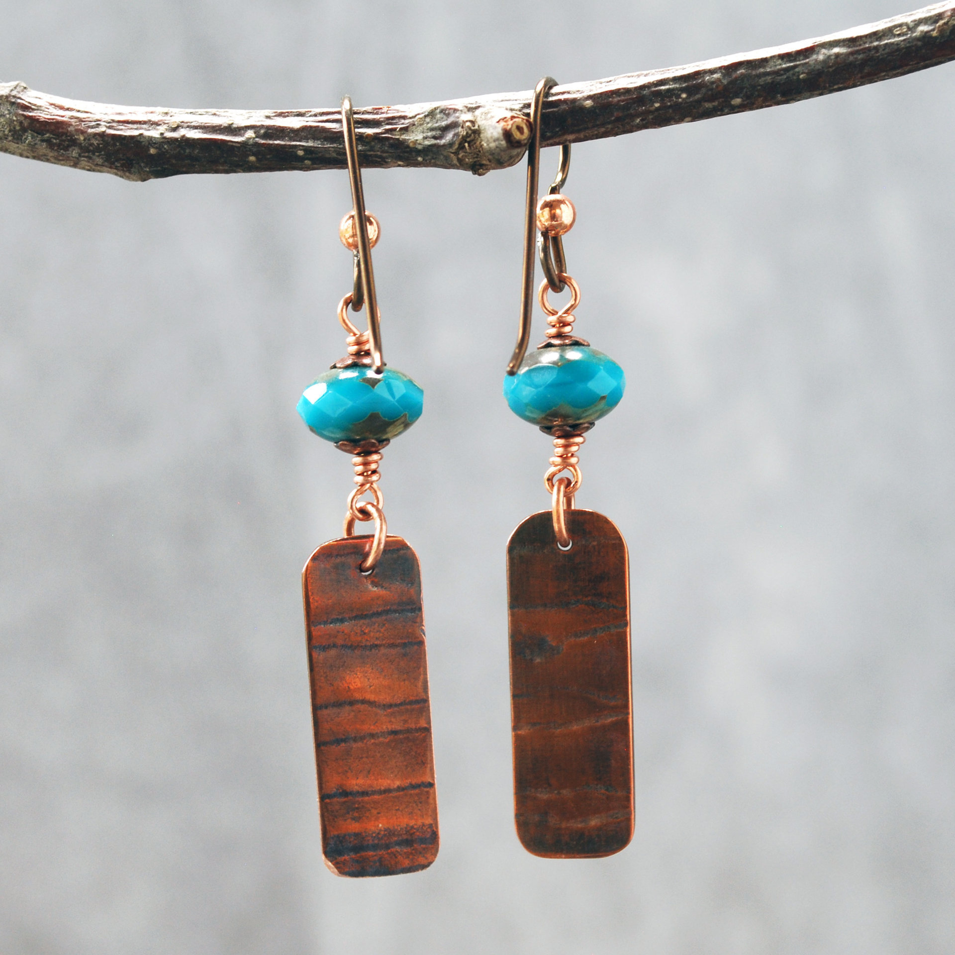Earrings with corrugated copper rectangle dangles and turquoise Czech glass bead on top, hanging