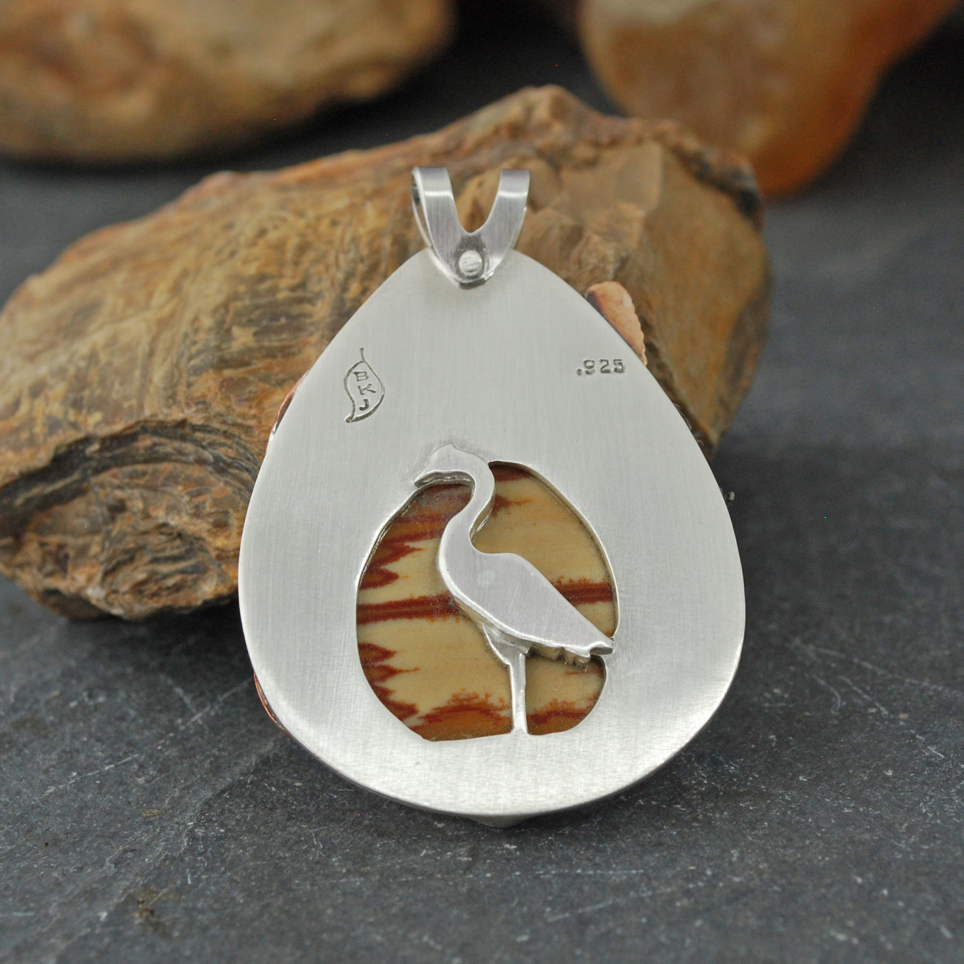 Owyhee Jasper and silver pendant back with heron in front of the cut-out stone back