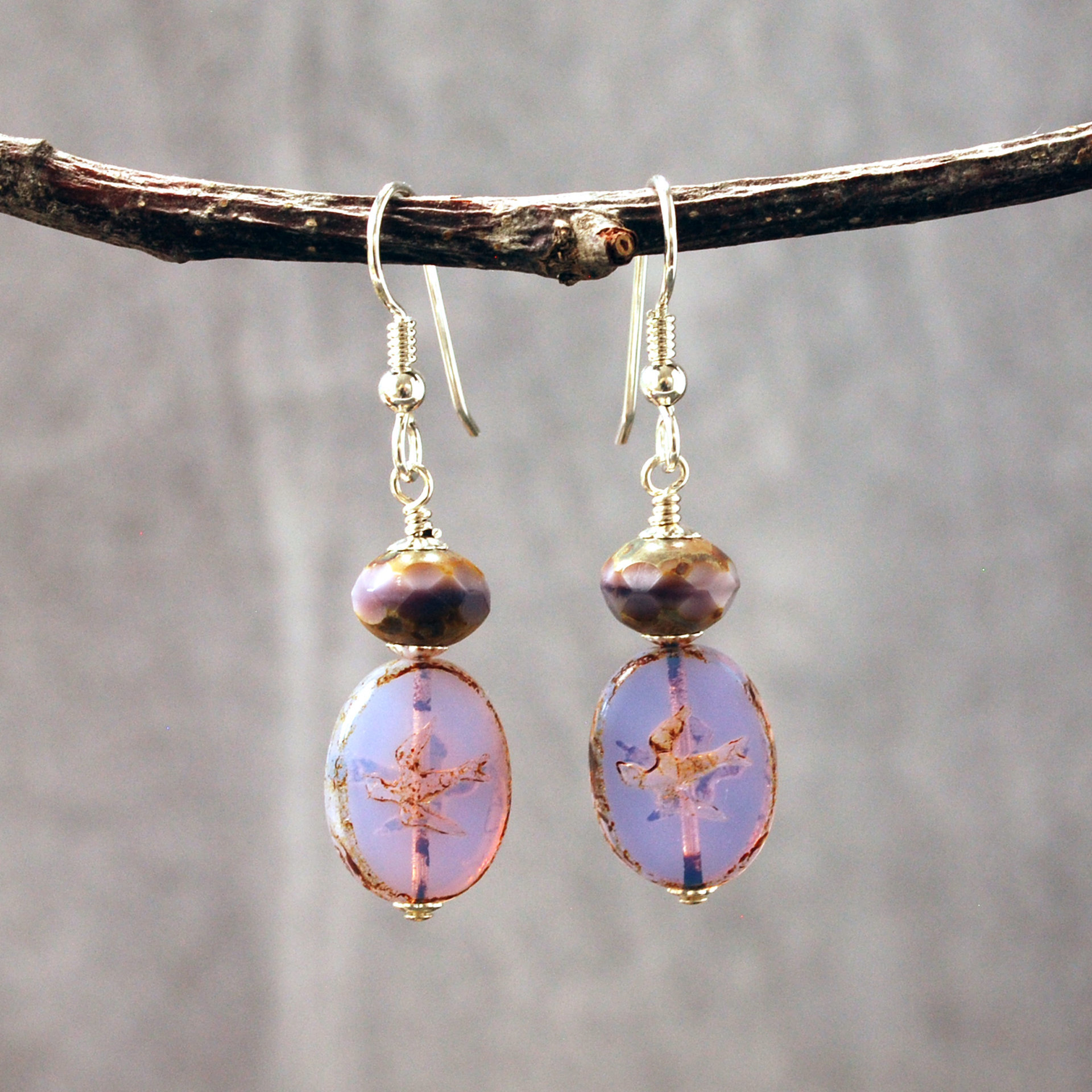 Pale purple Czech glass earrings, swallow embossed flat beads at bottom, topped by faceted rondelle beads, hanging