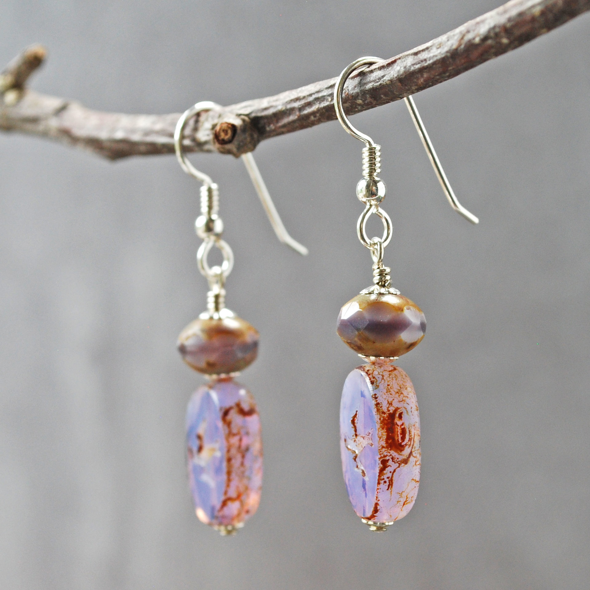 Pale purple Czech glass earrings, swallow embossed flat beads at bottom, topped by faceted rondelle beads, hanging