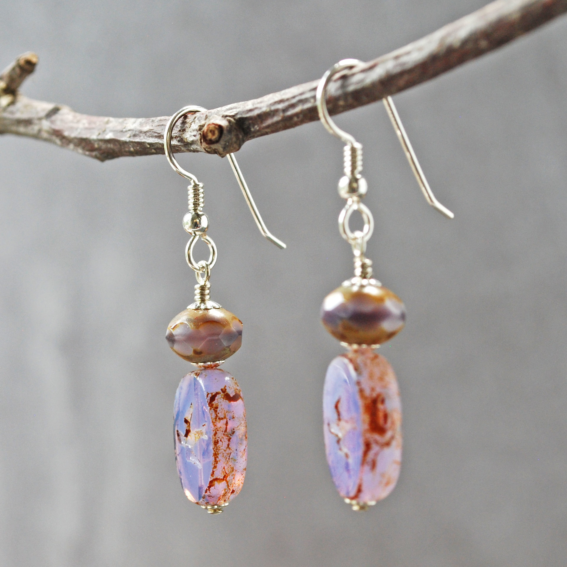 Pale purple Czech glass earrings, swallow embossed flat beads at bottom, topped by faceted rondelle beads, hanging