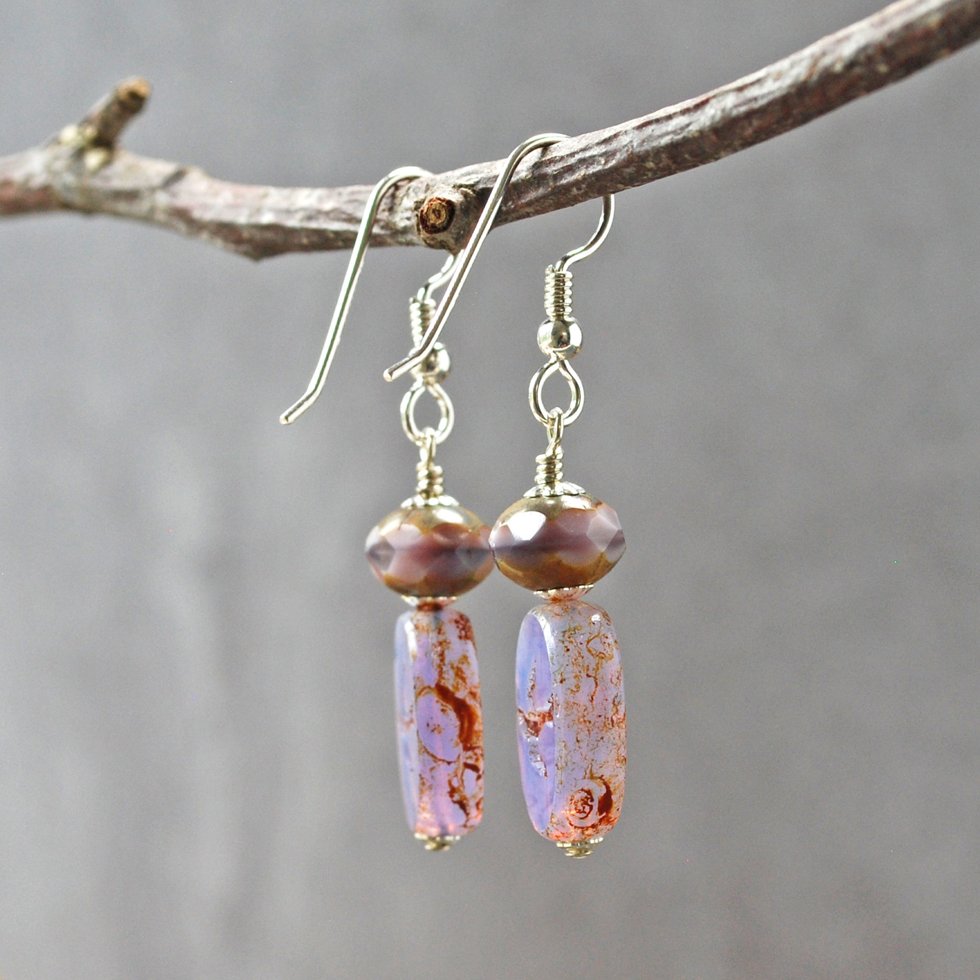 Pale purple Czech glass earrings, swallow embossed flat beads at bottom, topped by faceted rondelle beads, hanging
