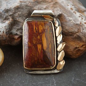 Silver and 14K Gold Pietersite Pendant against rocks